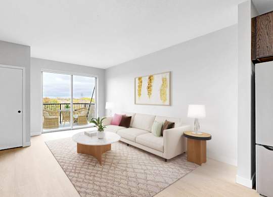 A living room with a white sofa, a wooden coffee table, and a flat-screen TV mounted on the wall.