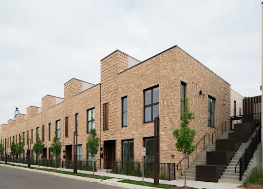 A long row of houses with a black iron fence in front.