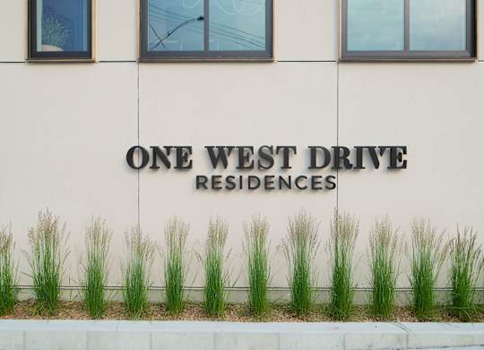 A building with a sign that says "One West Drive Residences".