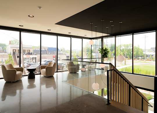 A spacious interior with a glass railing and a staircase.