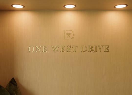 A wall with the words "One West Drive" on it.