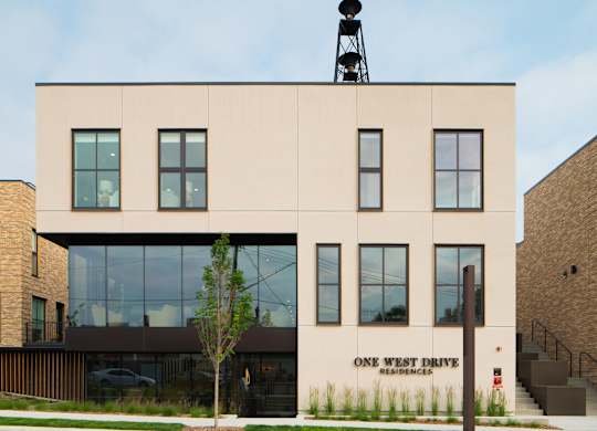 A building with a sign that says "One West Drive Residences" on the side.