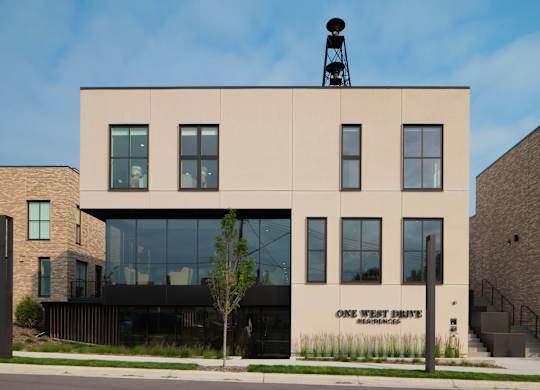 A building with a sign that says "One West Drive Residences" on the front.