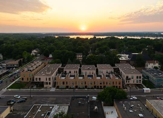 A sunset view of a town with a large building in the foreground.