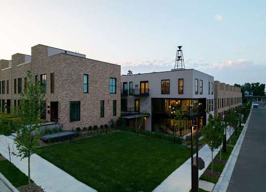 A modern building with a red car parked in front.