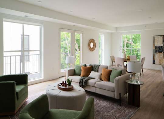 A living room with a green chair and a white couch.