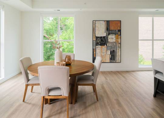 A dining room with a wooden table and chairs.