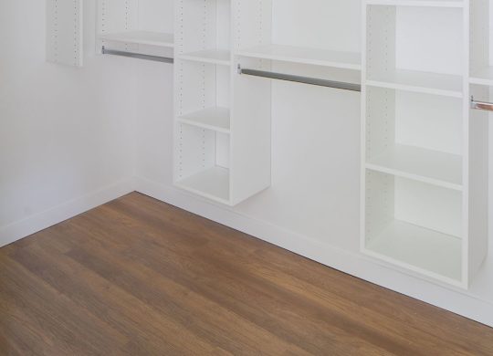 A white shelving unit with multiple shelves is mounted on a white wall.