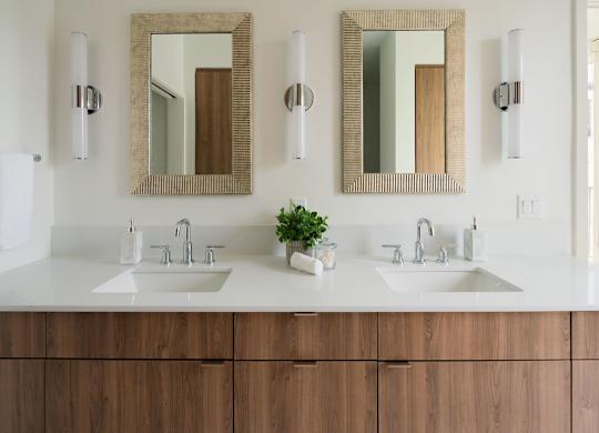 A bathroom with two sinks and two mirrors.