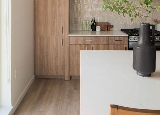 A kitchen with a wooden floor and a white table.