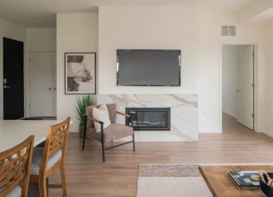 A modern living room with a fireplace and a flat screen TV mounted above it.