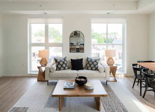 A living room with a white couch and a coffee table in the center.