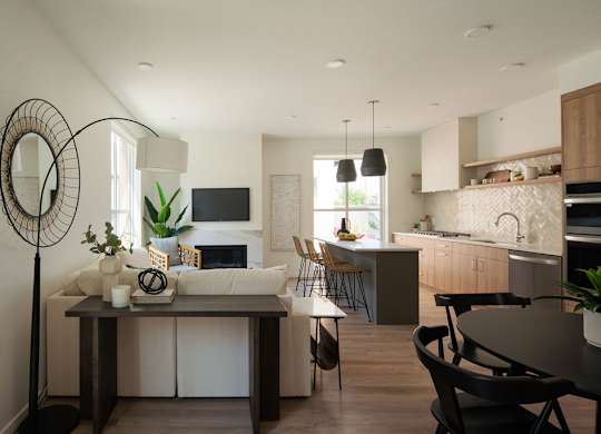 A modern kitchen with a dining table and chairs.