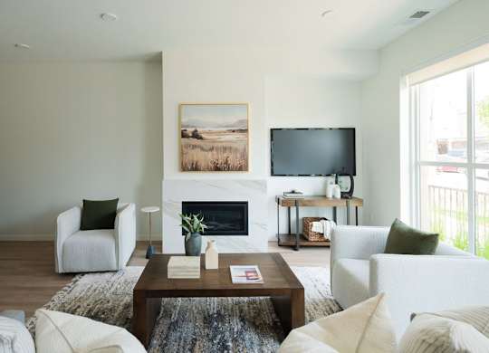 A living room with a fireplace and a painting on the wall.