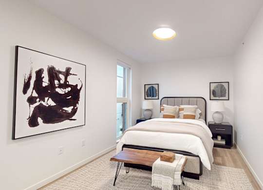 A bedroom with a large bed and a painting on the wall. at One West Drive Apartments, Excelsior, MN 55331