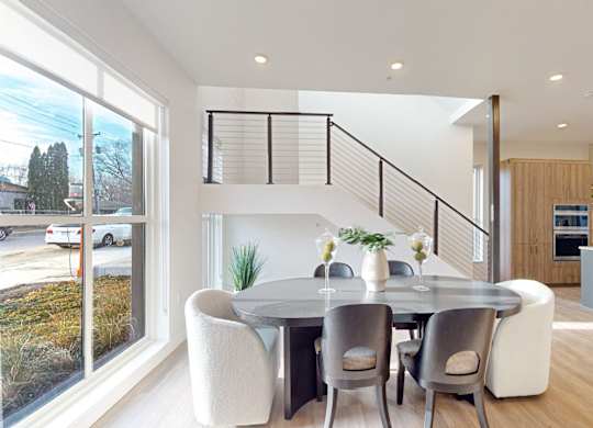 A modern dining room with a glass table and chairs. at One West Drive Apartments, Excelsior, MN 55331