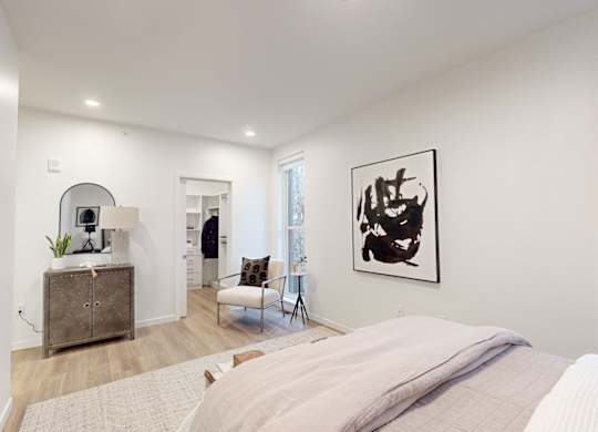 A bedroom with a large bed and a painting on the wall at One West Drive Apartments, Excelsior, Minnesota