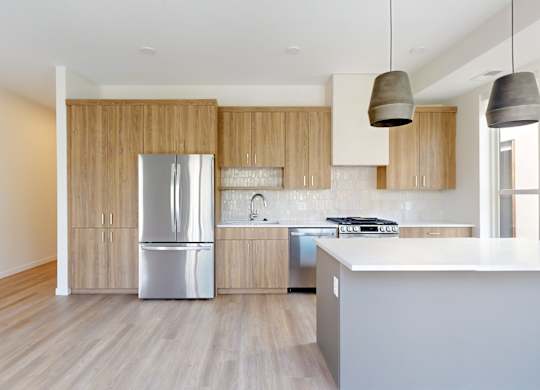 A modern kitchen with wooden cabinets and a white countertop at One West Drive Apartments, Excelsior, 55331