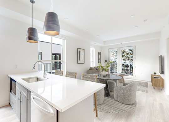 A modern kitchen with a large island and pendant lights.