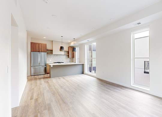 A spacious kitchen with wooden floors and white walls at One West Drive Apartments, Minnesota