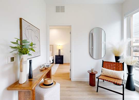 A room with a chair and a mirror on the wall.