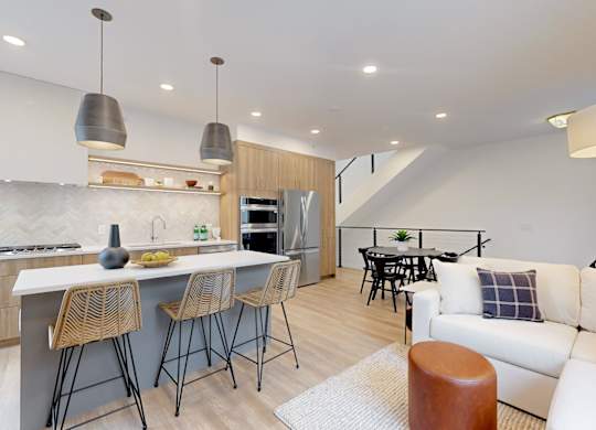 A modern kitchen with a bar area and a living room area.