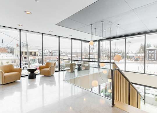 A spacious lobby with a glass railing and a staircase.