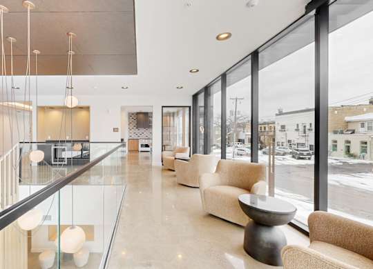 A modern living room with a glass railing and a glass table.