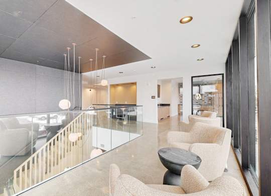 A modern living room with a glass table and white chairs.