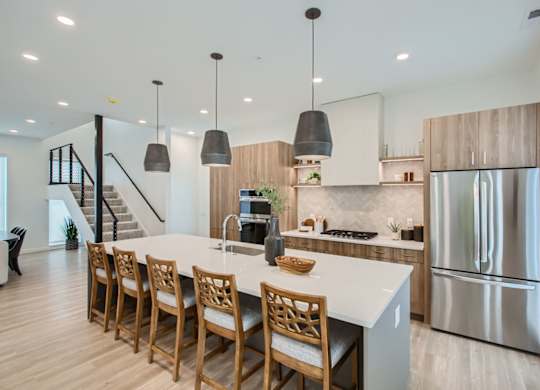 a kitchen with a large island and a stainless steel refrigerator at One West Drive Apartments, Excelsior, Minnesota
