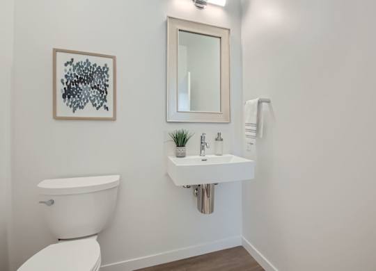 a bathroom with a sink and a toilet and a mirror at One West Drive Apartments, Excelsior