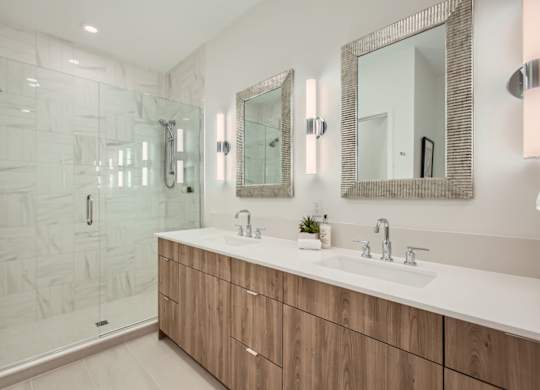 a bathroom with two sinks and a shower at One West Drive Apartments, Excelsior, Minnesota