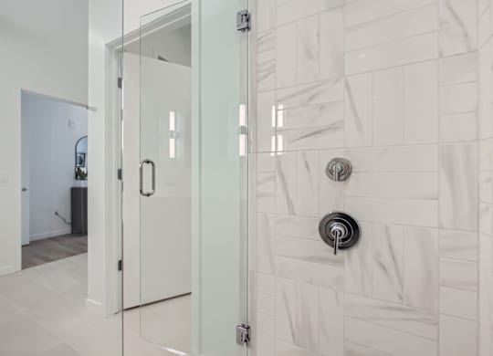 a white bathroom with a glass shower door at One West Drive Apartments, Excelsior, 55331