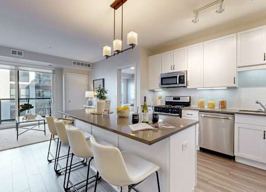 A modern kitchen with white cabinets and a large island.
