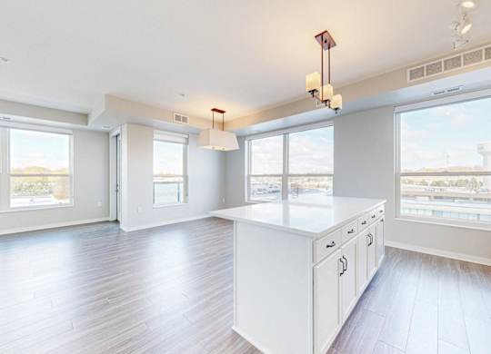 A spacious kitchen with white cabinets and a large island.