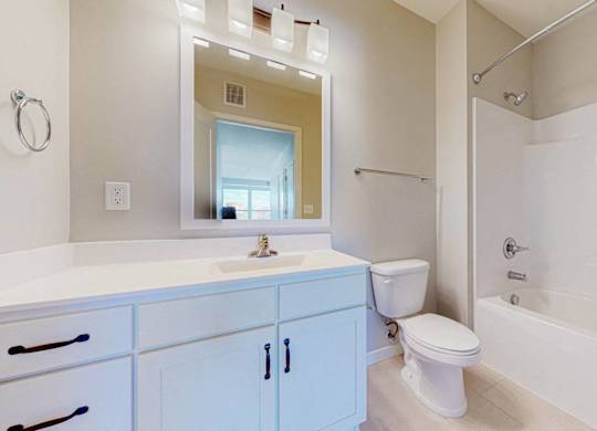 A white bathroom with a blue cabinet.