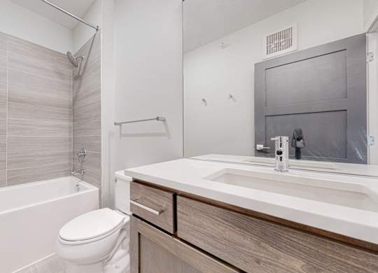 A white toilet sits next to a white sink in a modern bathroom.