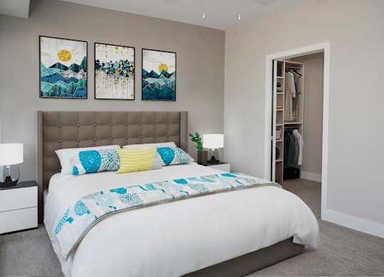A bedroom with a large bed and two paintings on the wall.