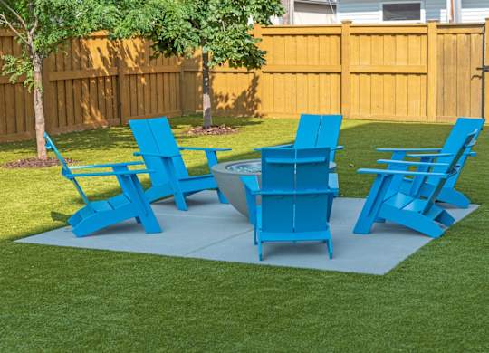 A set of blue lawn furniture is arranged on a green lawn.