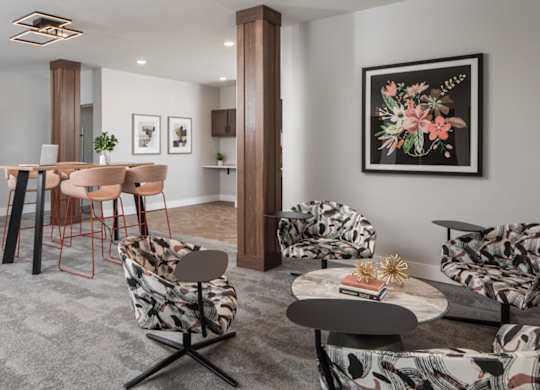 A living room with a grey carpet and a large painting on the wall.at The Edison at Maple Grove, Minnesota