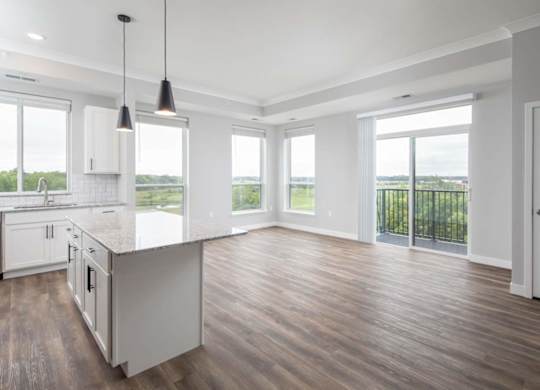 A kitchen with white cabinets and a wooden floor.at The Edison at Maple Grove, Maple Grove, MN