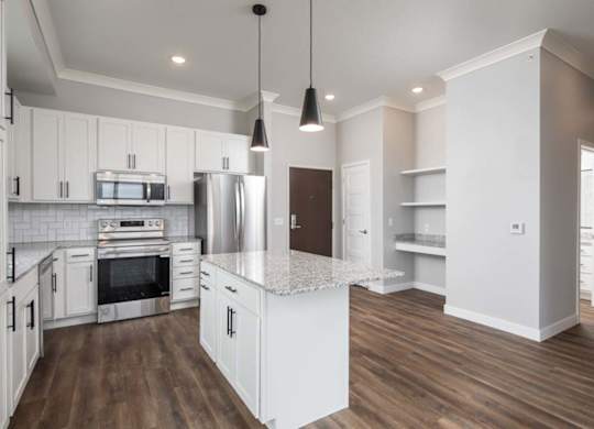 A kitchen with white cabinets and a wooden floor.at The Edison at Maple Grove, Maple Grove, 55311