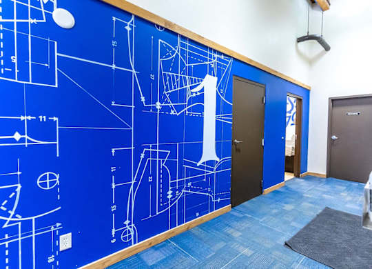 A hallway with a blue wall covered in architectural drawings.at Lee Lofts, Minnesota, 55401