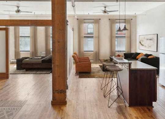 A living room with a brown floor and a white ceiling.at Lee Lofts, Minneapolis, MN