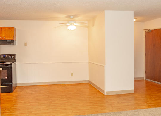 A room with a ceiling fan and a door.