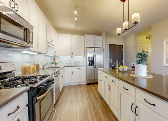 a large kitchen with white cabinets and stainless steel appliances
