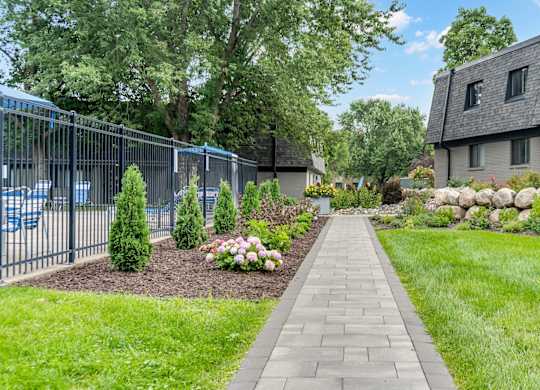 A walkway leads through a landscaped area with a building in the background.