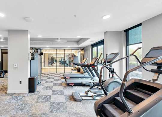 A spacious gym with treadmills, elliptical machines, and other exercise equipment.