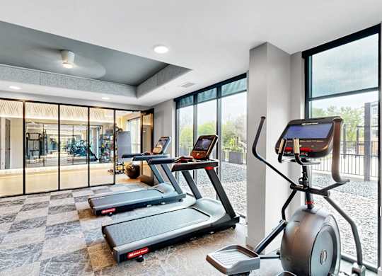 A modern home gym with treadmills and exercise bikes.