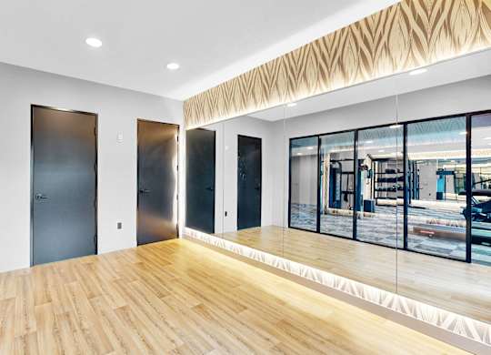 A room with wooden floors and a large window overlooking a city street.